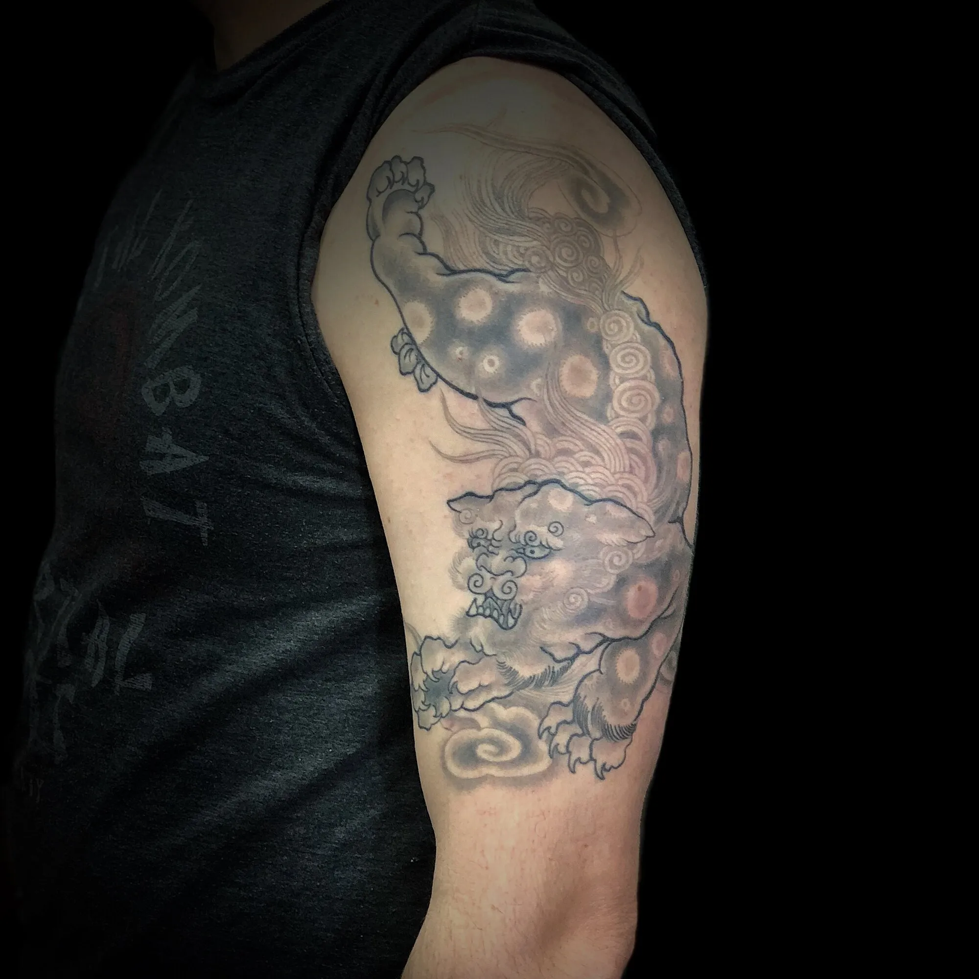 Black and grey Japanese foo dog half sleeve tattoo with clouds by Josh Robinson in Dallas, TX