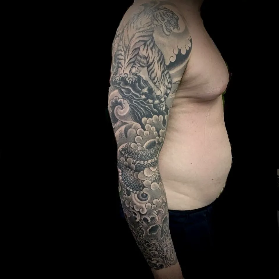 Black and grey Japanese tiger and dragon full sleeve tattoo with waves by Josh Robinson in Dallas, TX