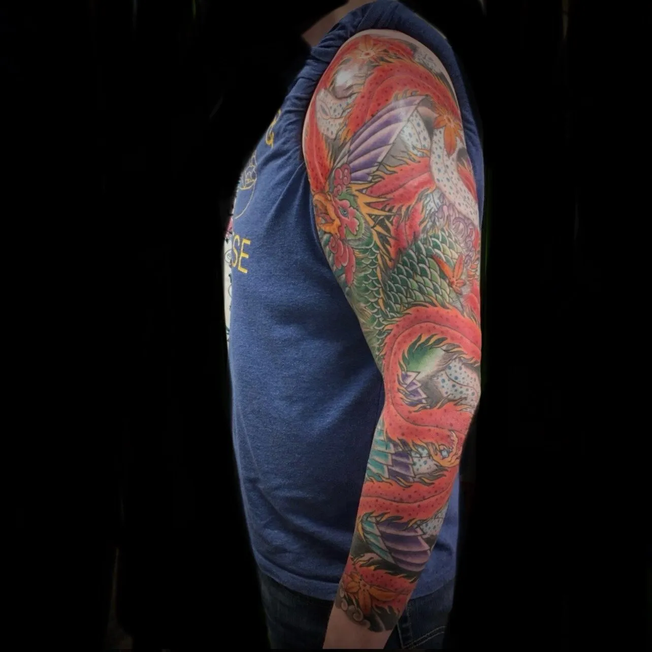 Japanese dragon and peony full sleeve tattoo in red and green by Josh Robinson in Dallas, TX