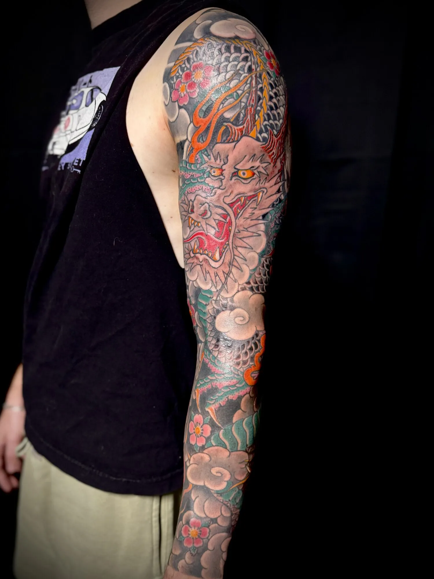Japanese dragon full sleeve tattoo in color with clouds and waves by Josh Robinson in Dallas, TX