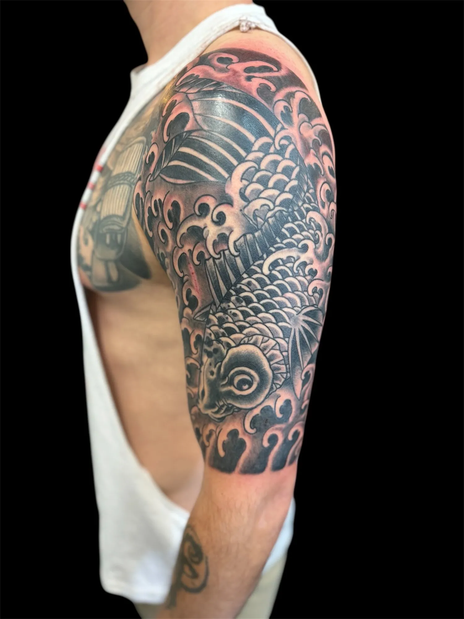Japanese koi fish and waves half sleeve tattoo with red accents by Josh Robinson in Dallas, TX