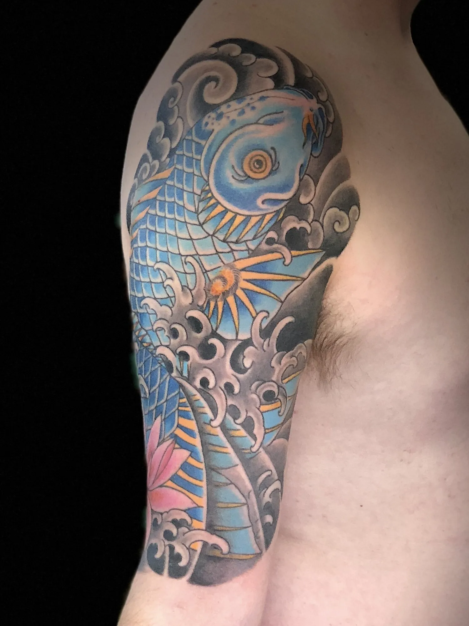 Japanese koi fish half sleeve tattoo with waves and lotus by Josh Robinson in Dallas, TX